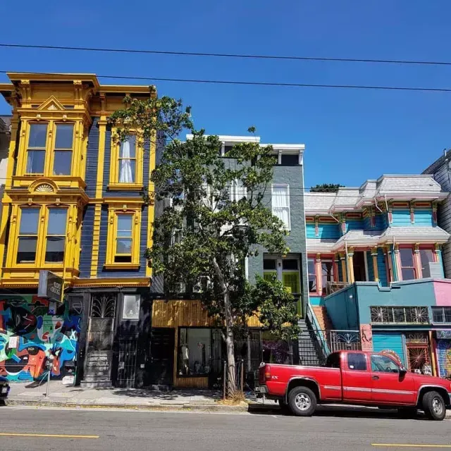 View of colorful buildings on Haight Street with cars parked along the street. San Francisco, California.